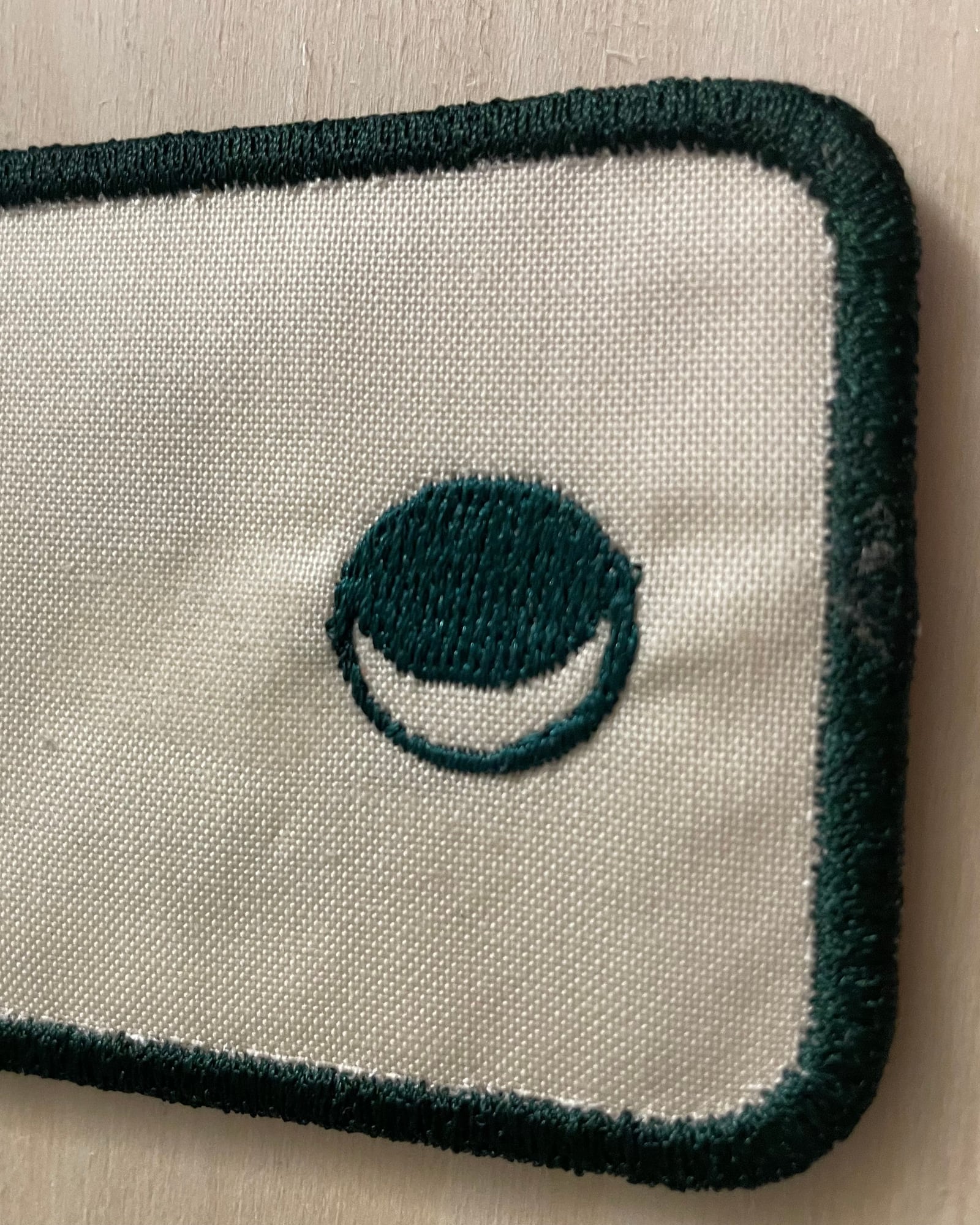 A close-up of the embroidered moon mark on the back.