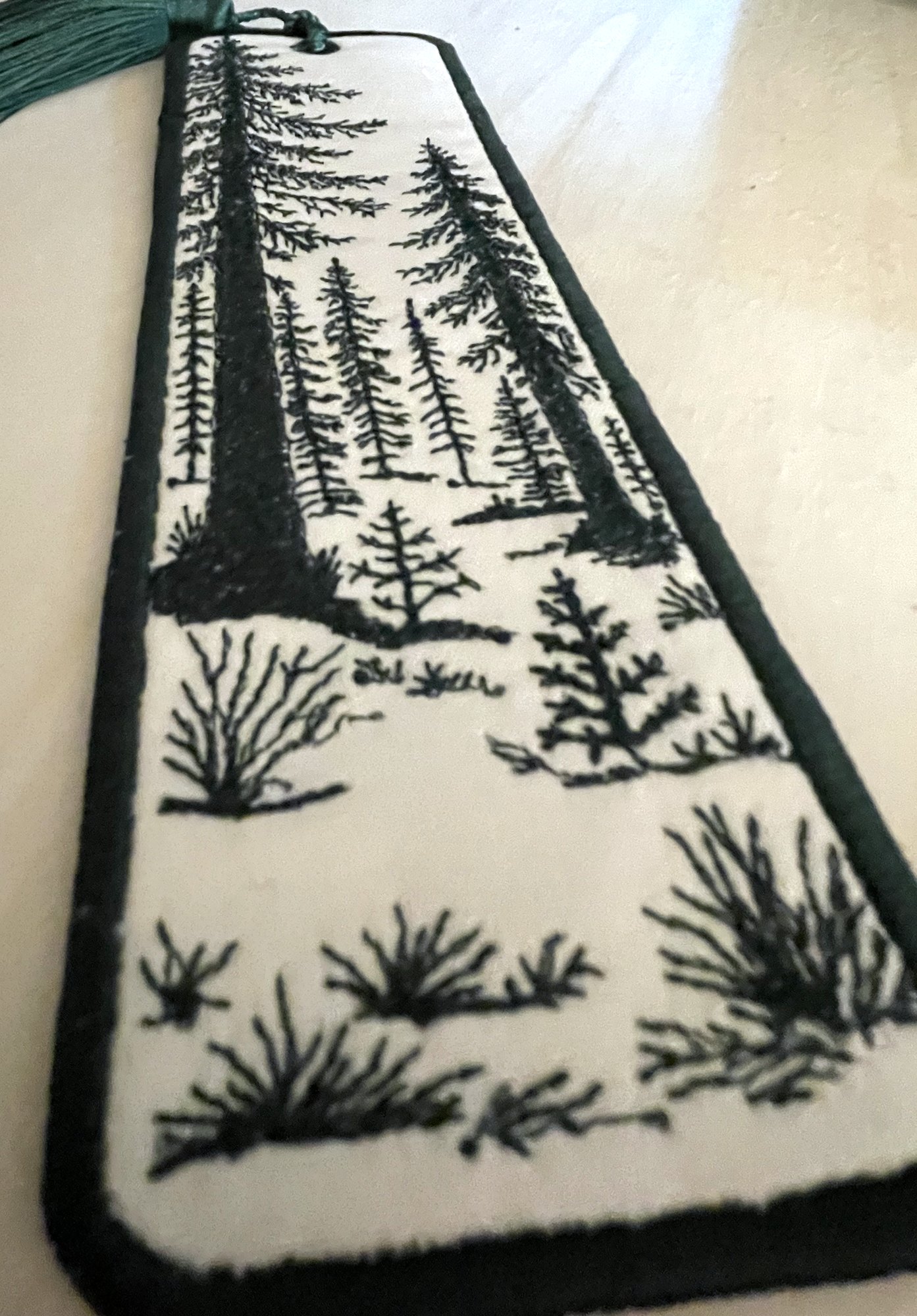 A close-up at an angle, showing the texture of the stitched trees and brush.